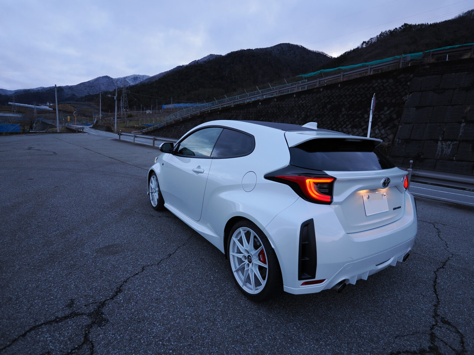 ワインディングに入る前の早朝の駐車場。GRヤリスが停車している。
